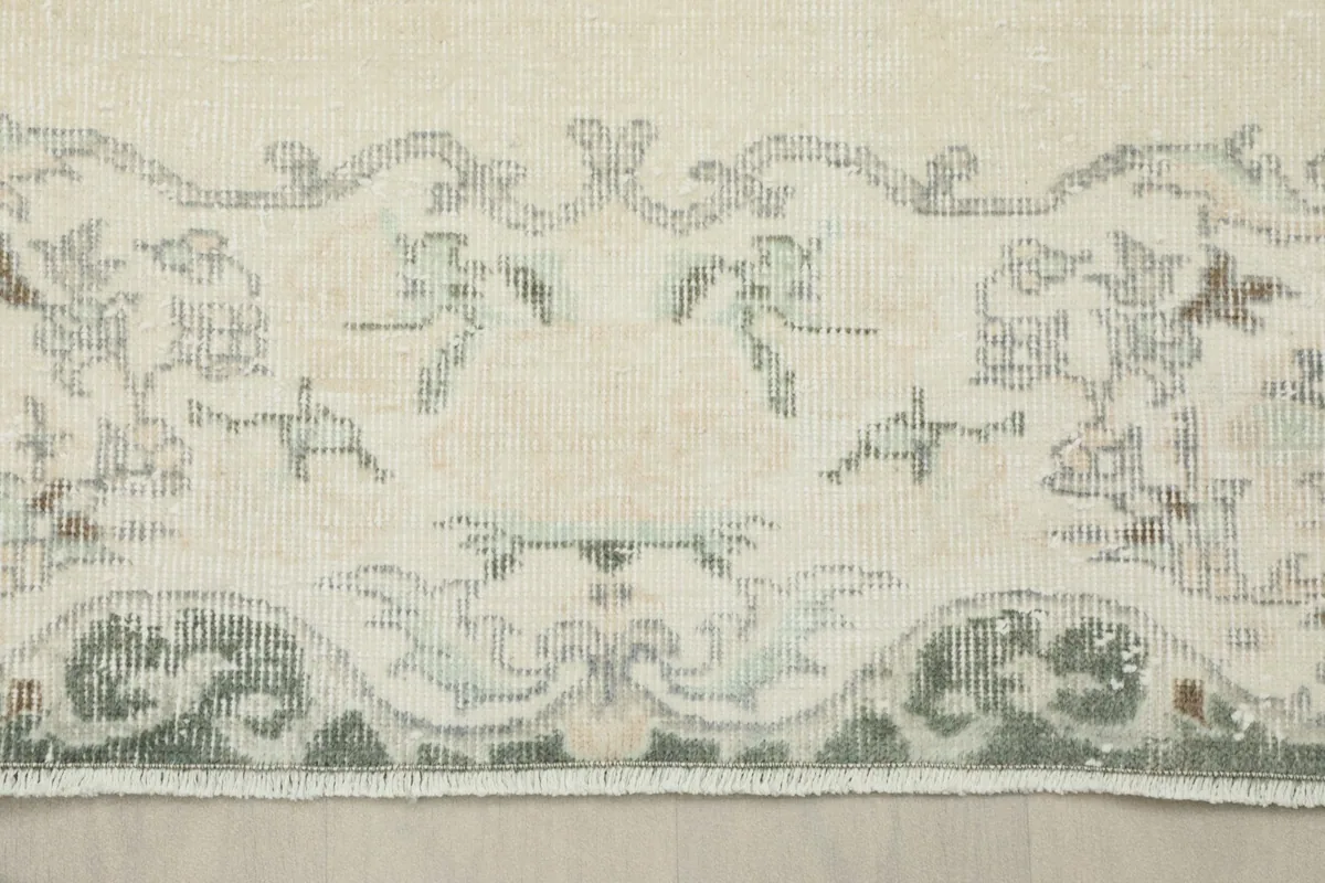 Close-up of the border pattern, showing the transition from the ivory field to the gray design