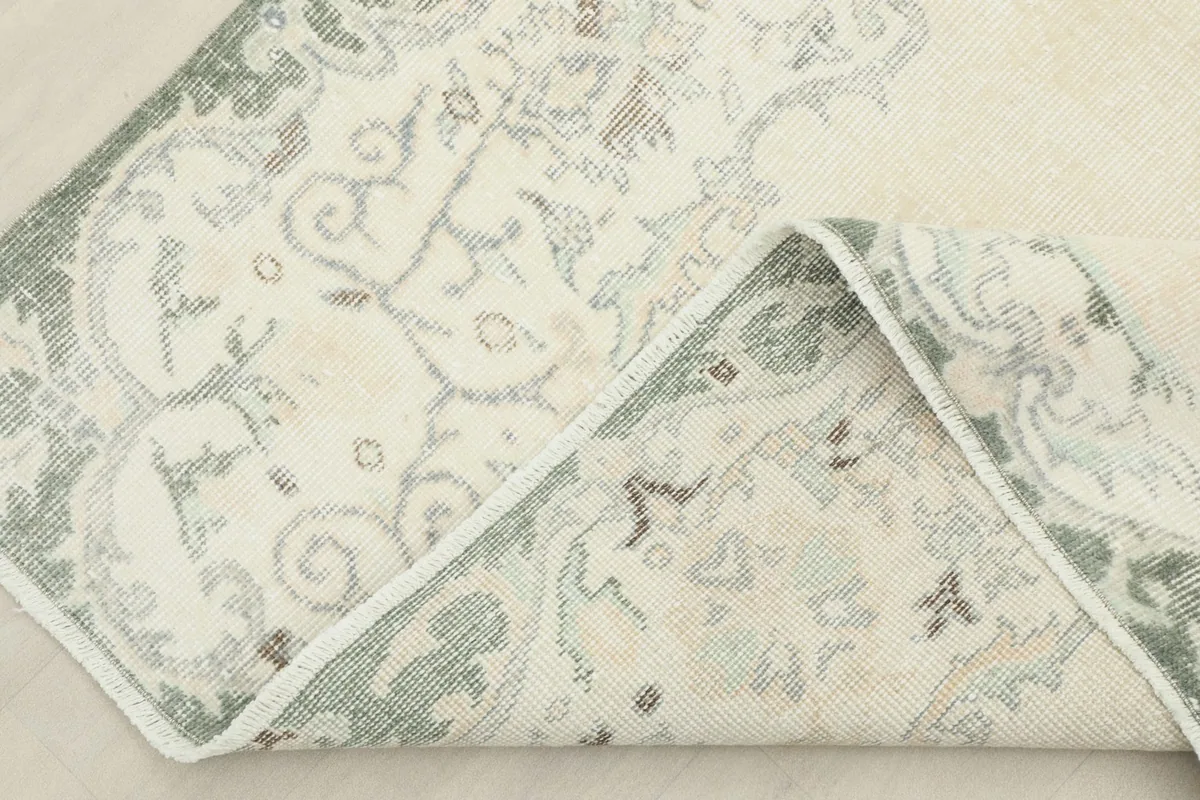 Corner of the hand-knotted rug folded back, revealing the reverse side and quality
