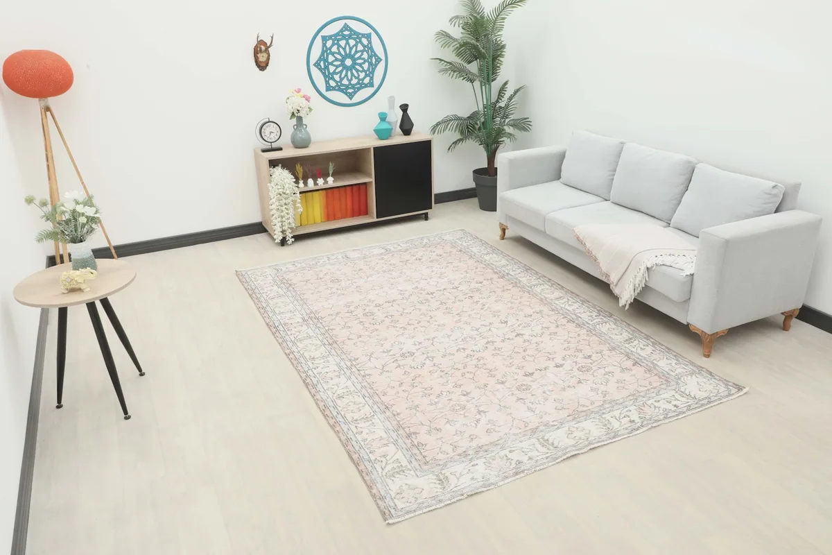 Soft rose floral vintage rug styled in a living room setting with a sofa