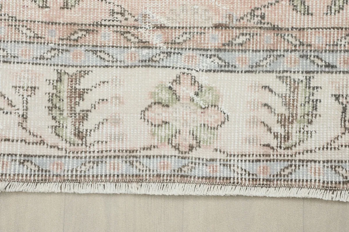 Close-up of the rug's border with decorative floral and geometric elements