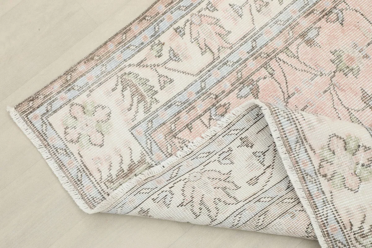 Folded corner of the rug showing the reverse side and hand-knotted construction