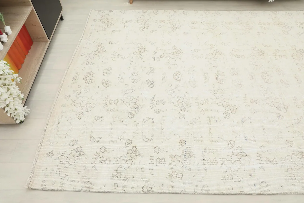 Angled view of the rug's corner and edge, highlighting its soft color palette