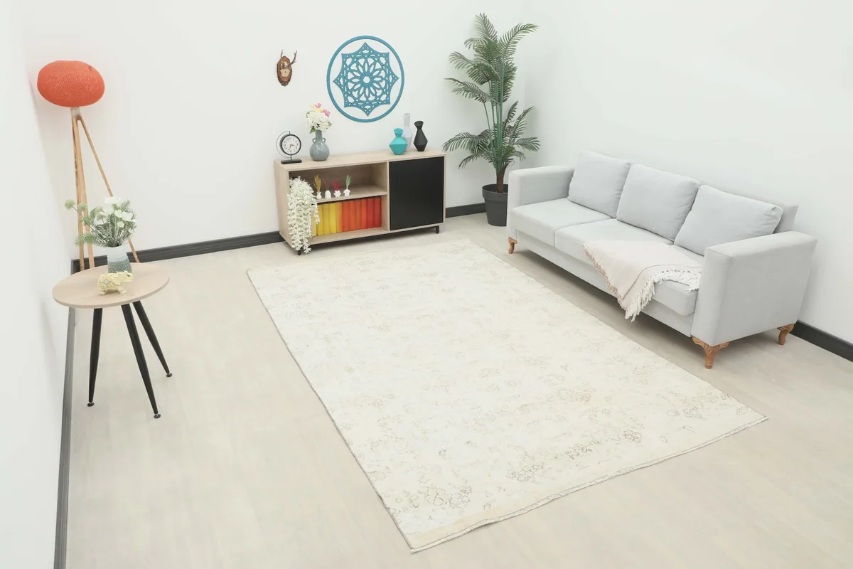 Large ivory area rug displayed in a bright living room setup with a gray sofa