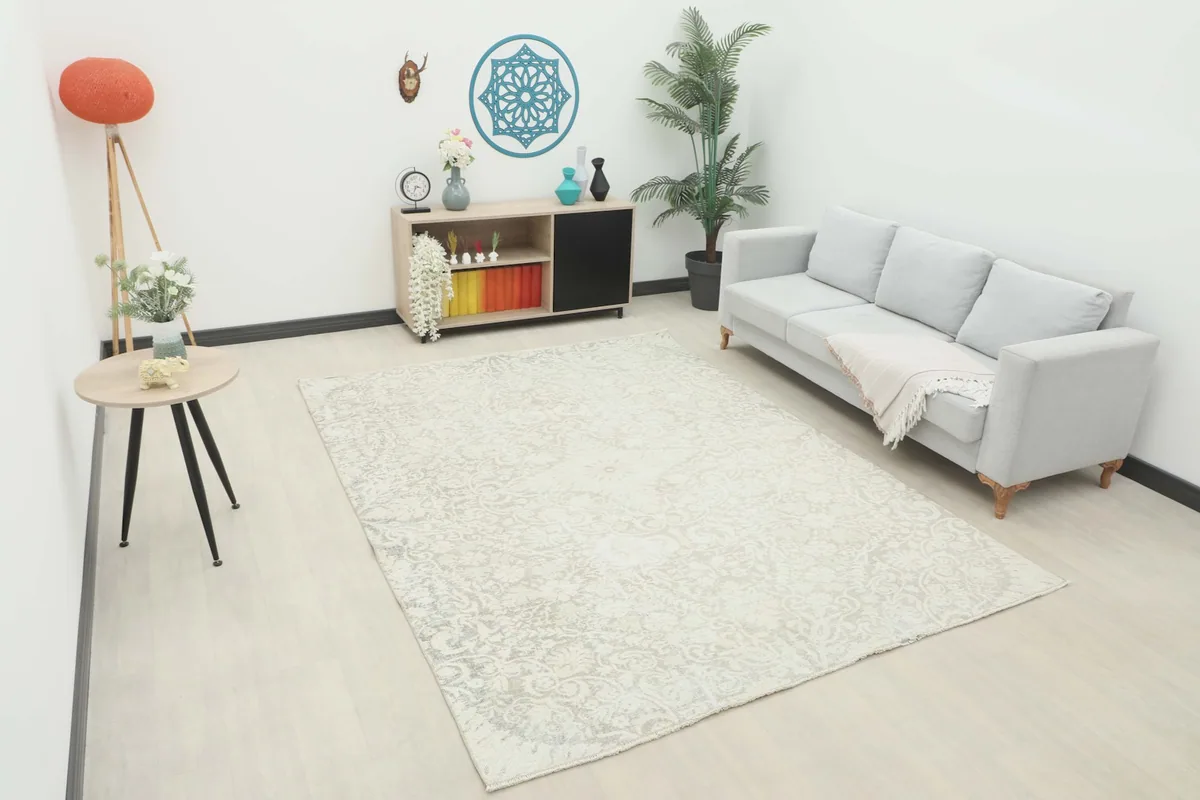 Vintage ivory and gray rug displayed in a bright living room setting with a light gray sofa