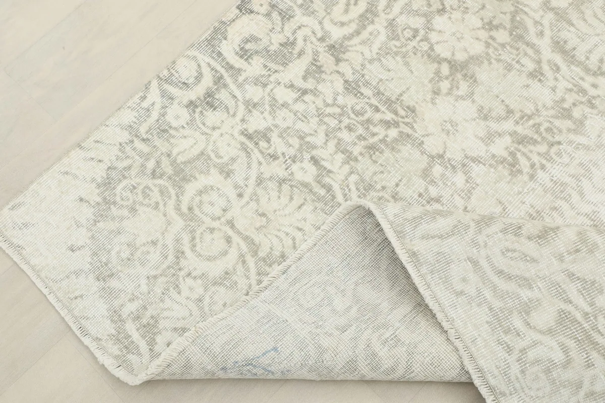 Folded corner of the rug revealing the hand-knotted construction and cotton foundation