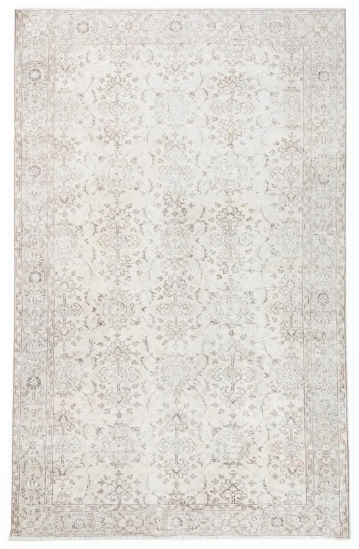 Full overhead view of an ivory vintage Anatolian area rug with muted beige floral patterns