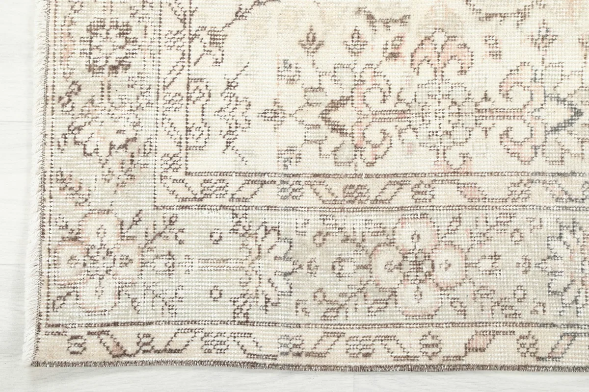 Detailed view of the rug's outer border with geometric motifs and a corner