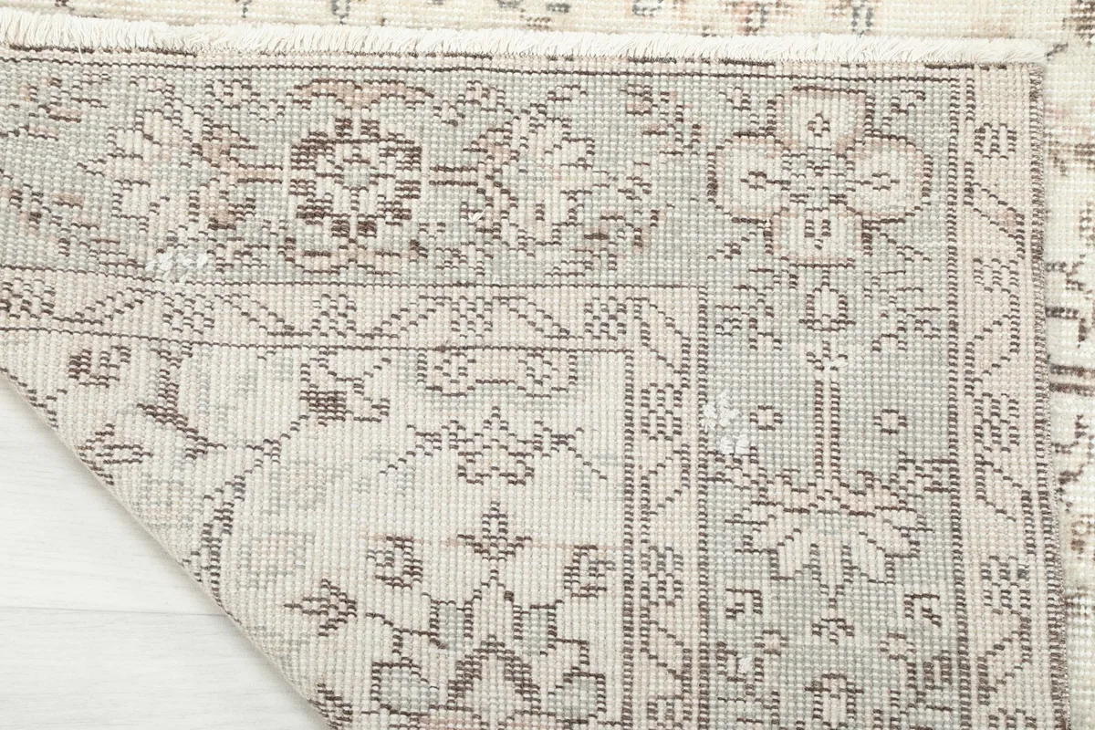 Close-up of the rug's reverse side, revealing the hand-knotted cotton foundation