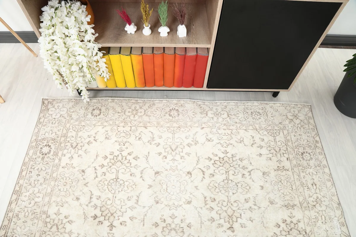 Overhead detail view of the rug's field and border patterns near room decor