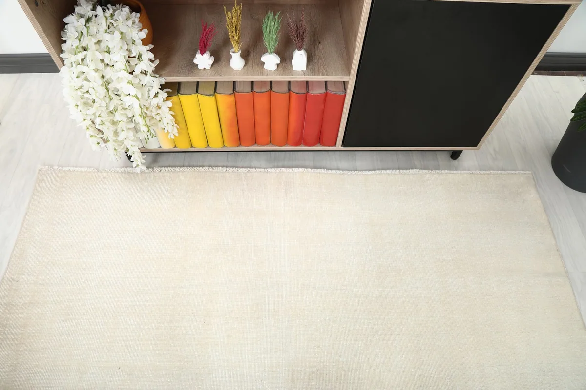 Detail shot of the cream rug's surface, showing its blend with the room's decor.