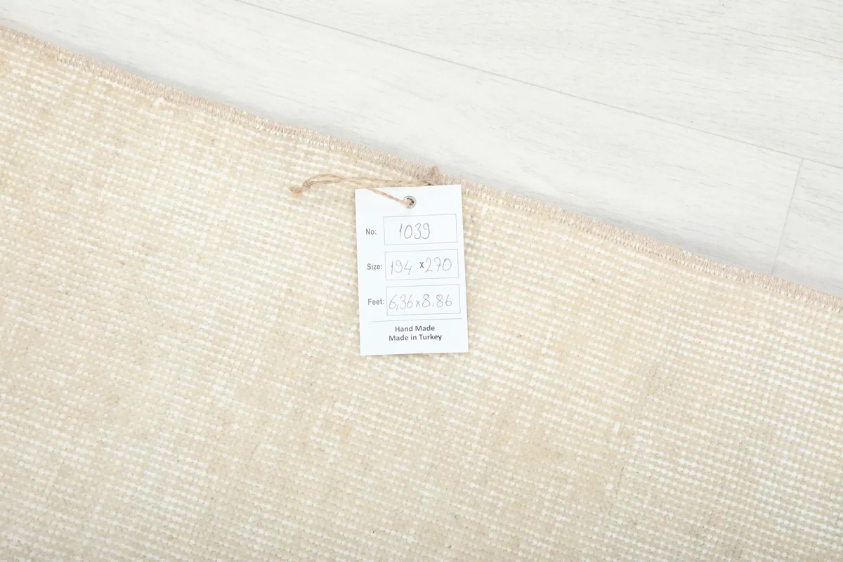Close-up of the care tag on the back of the rug, detailing its origin and material.