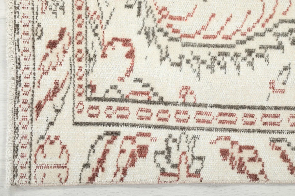 Corner detail displaying the border pattern and the subtle wear characteristic of vintage rugs.