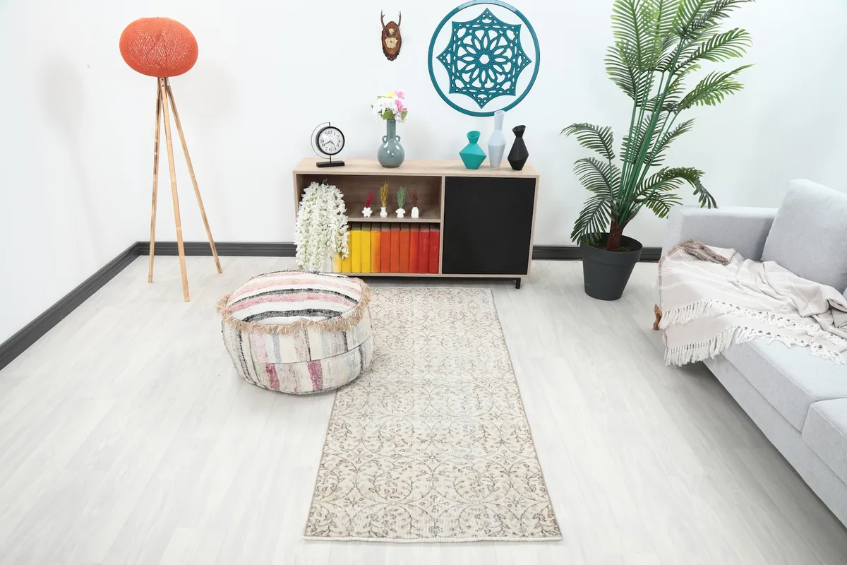 Cream and tan runner rug placed in a modern living room setting with light furniture.