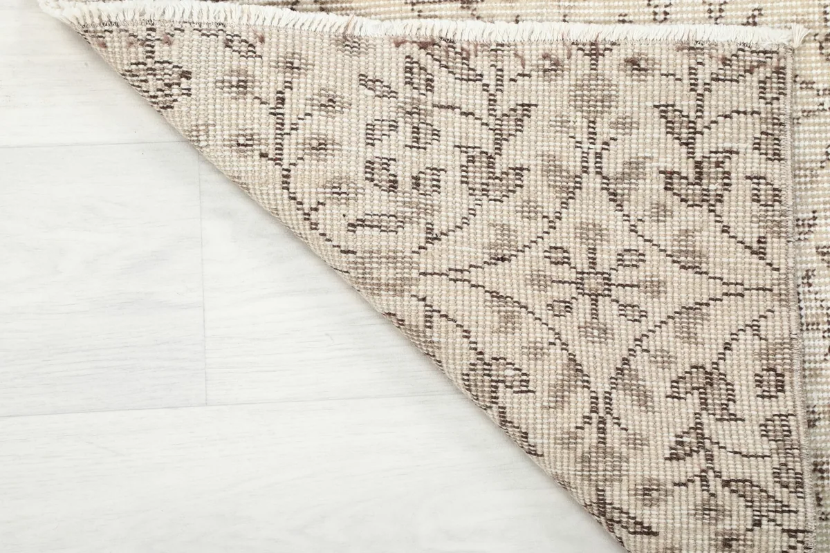 Underside of the rug's corner, showing the hand-knotted construction and foundation.