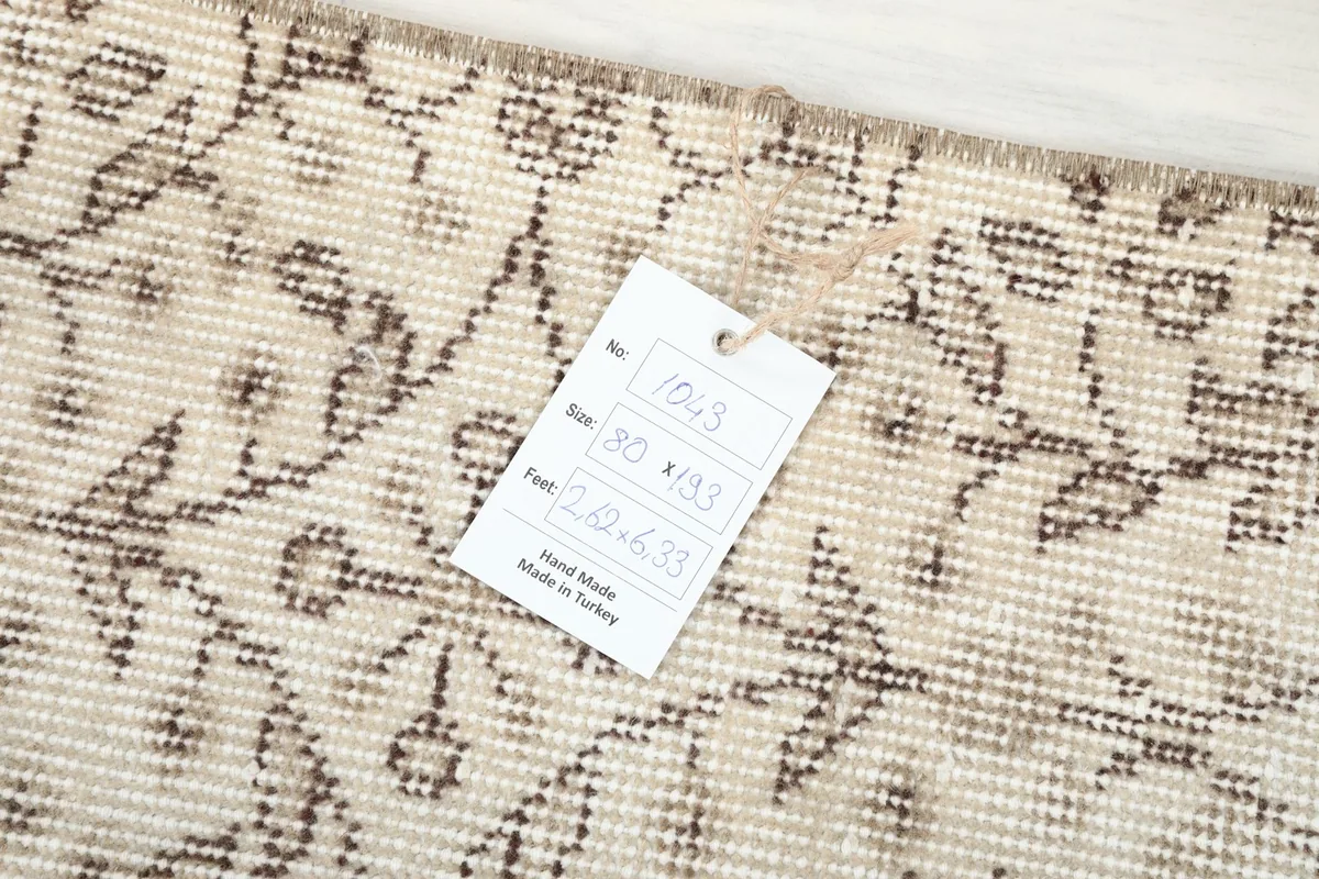 Product tag attached to the rug, displaying item number, size in cm and feet, and 'Hand Made in Turkey'.