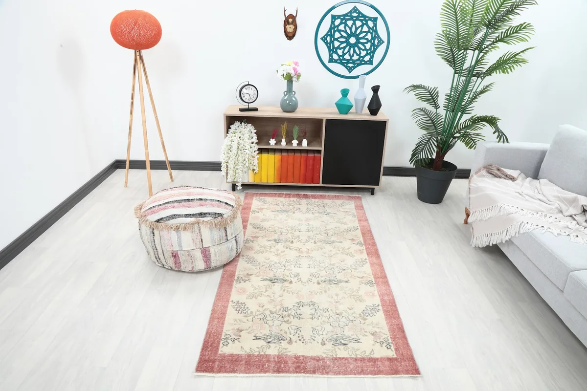 Vintage ivory and rose rug in a living room setting with a light gray sofa and wooden furniture