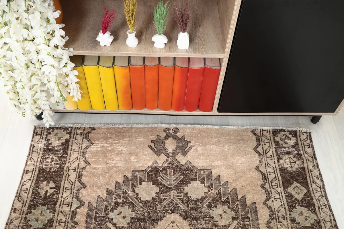 Detail of the rug's upper section in a styled room, showing books and decor.