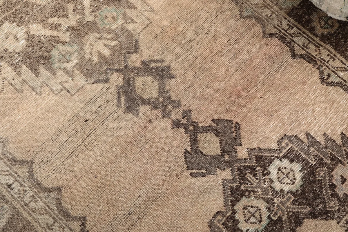 Close-up of the central geometric motifs and the subtle color variations in the pile.