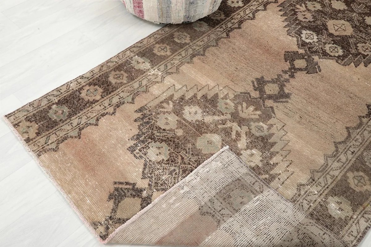 Corner of the rug folded back, showing the wool pile and cotton foundation.