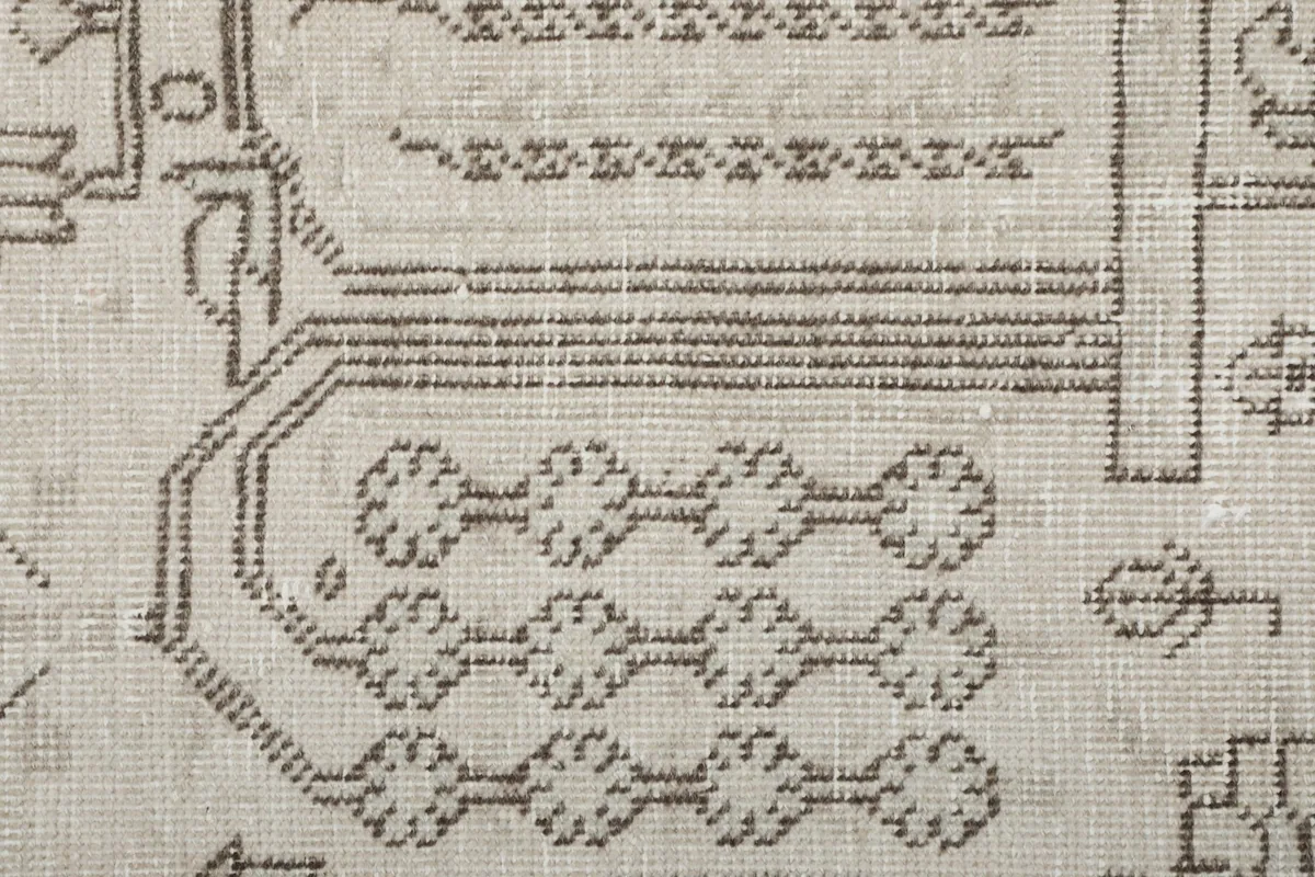 Detailed view of the gray patterned elements and texture within the ivory field.