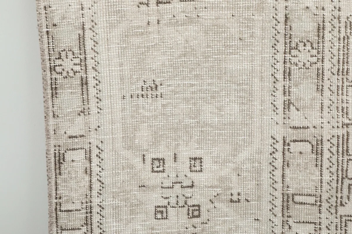 Close-up of a section of the rug, showing the geometric patterns and distressed finish.