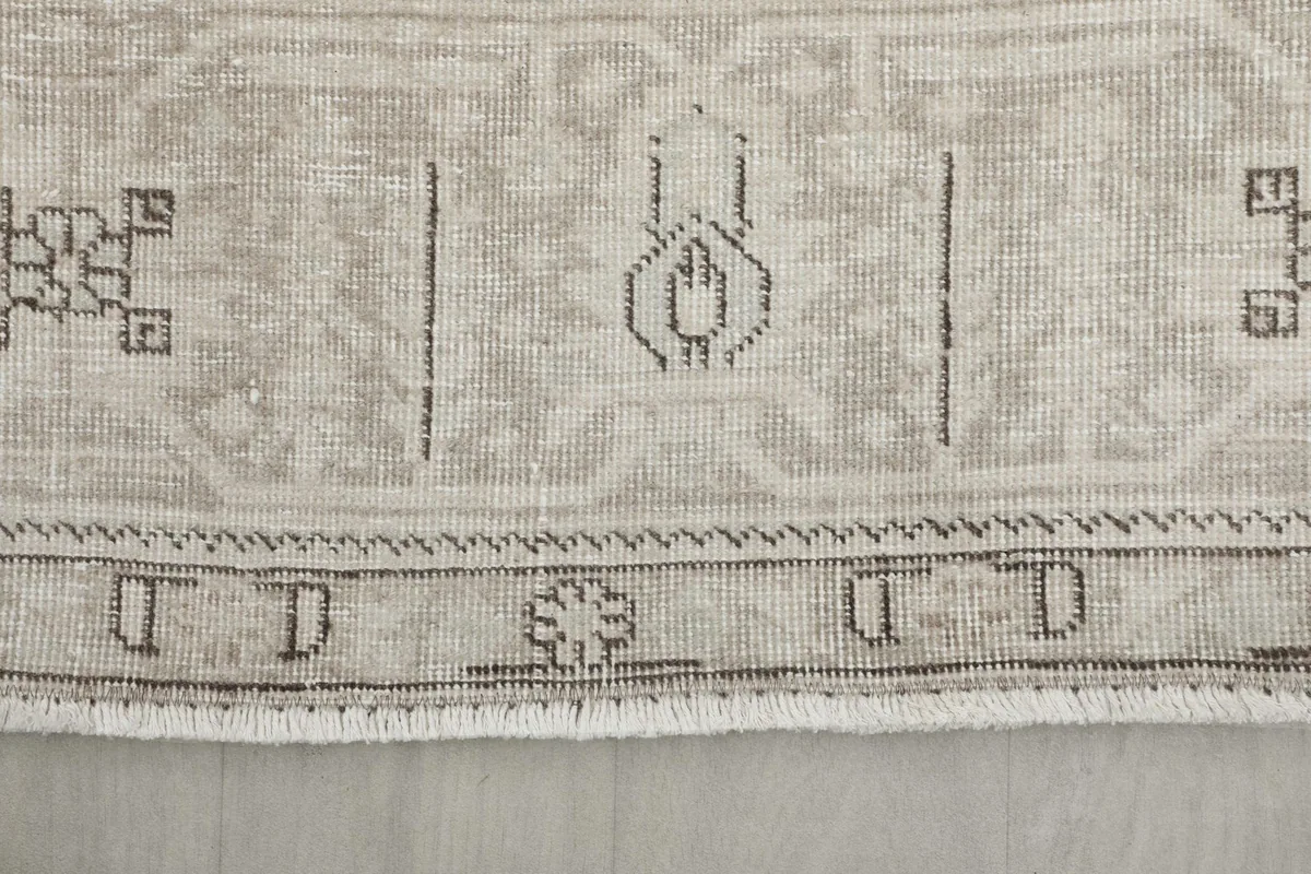 Close-up of the rug's edge, showing the subtle fringe and border details.