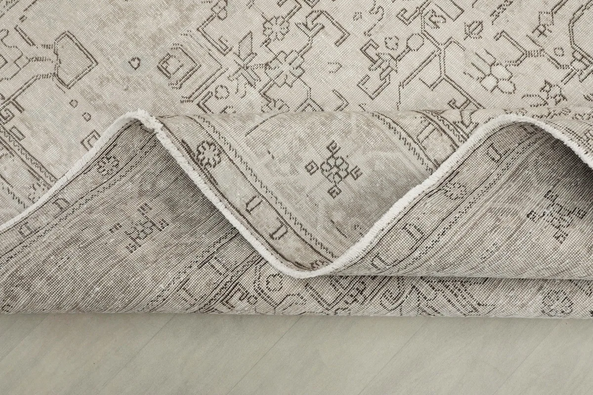 Side view of the rug folded, showing the soft wool pile and cotton foundation.