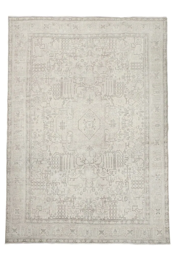 Direct overhead shot of the hand-knotted ivory Persian rug with geometric patterns.