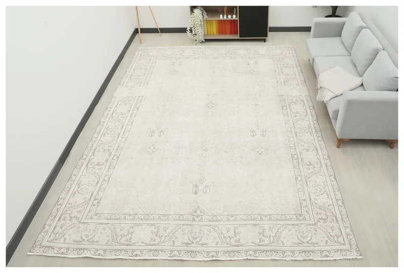 Full top view of the ivory and gray distressed Persian rug on a white background.