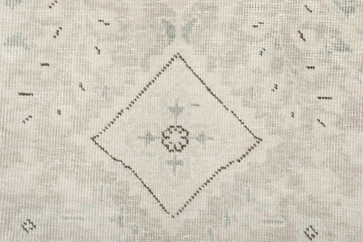 Detailed view of the rug's surface, revealing a faint green accent within a gray motif.