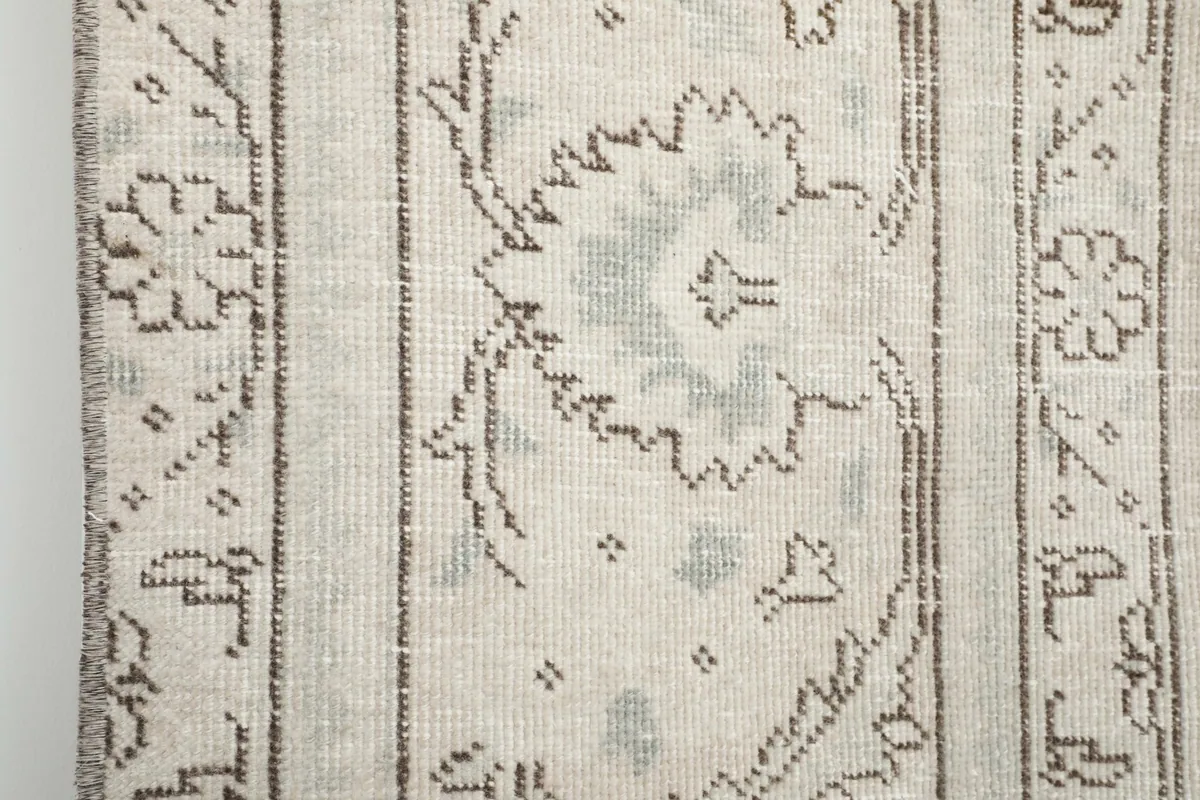 Close-up of the rug's side border, highlighting the detailed patterns and color variations.