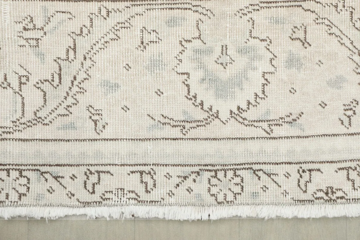 Close-up of the rug's fringe and the detailed outer border with floral elements.