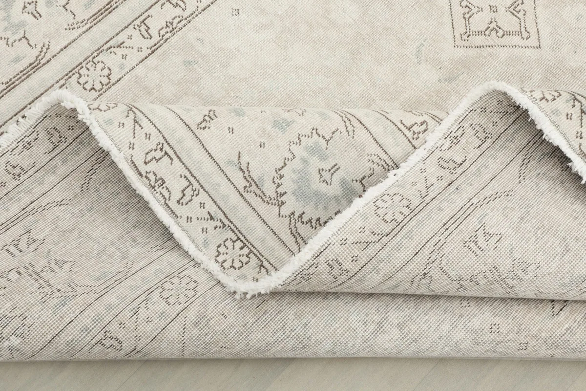 Another view of the folded rug, emphasizing the texture and softness of the vintage wool.