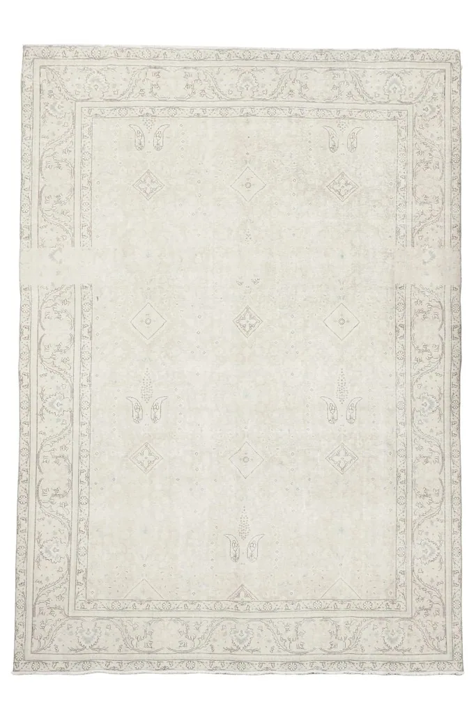 Overhead view of the vintage Persian rug, highlighting its subtle floral and geometric patterns.