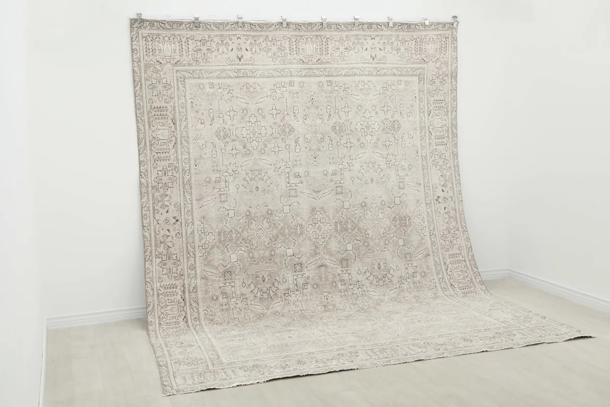 Angled view of the rug hanging, emphasizing its large size and presence.