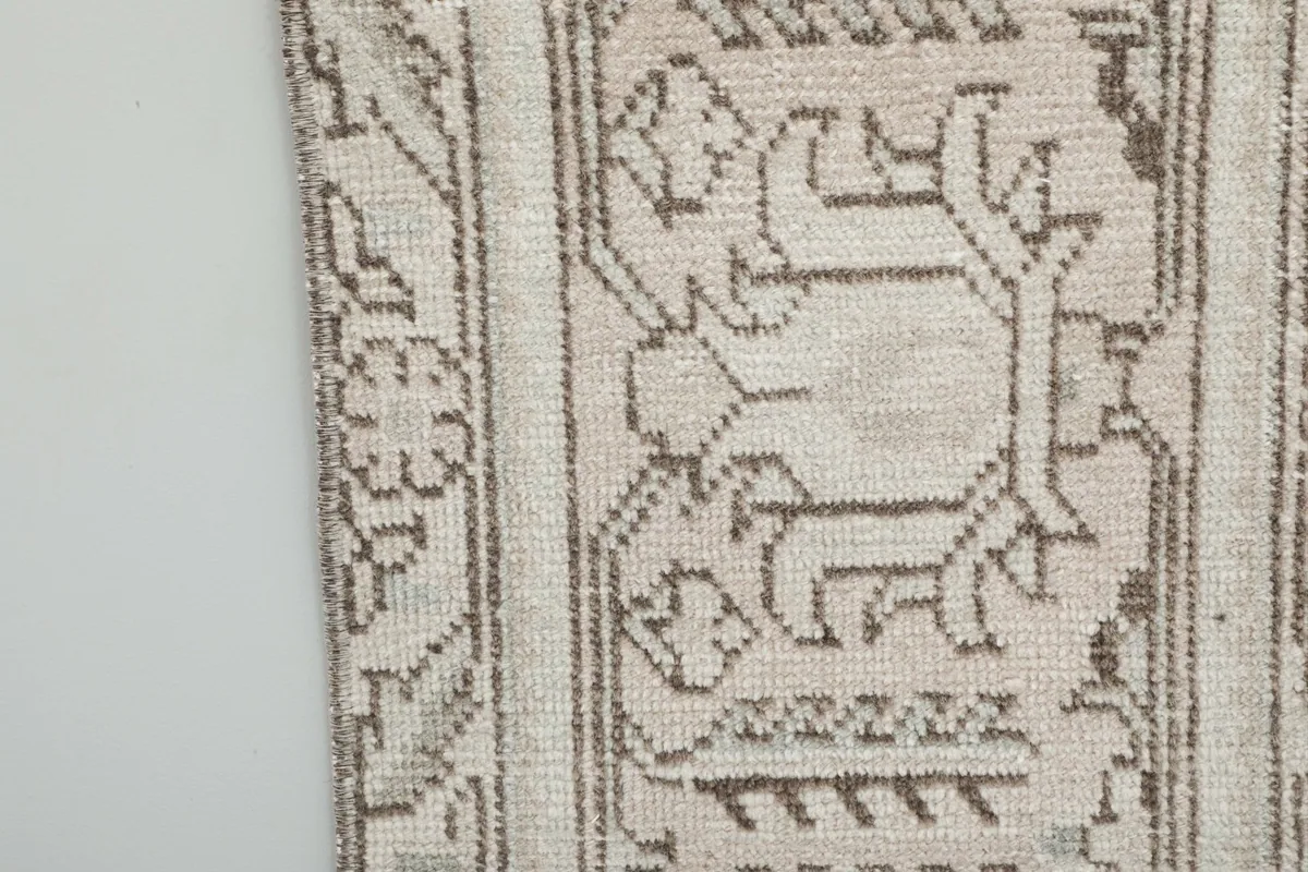 Extreme close-up of the rug's edge, showing individual knots and subtle color variations.