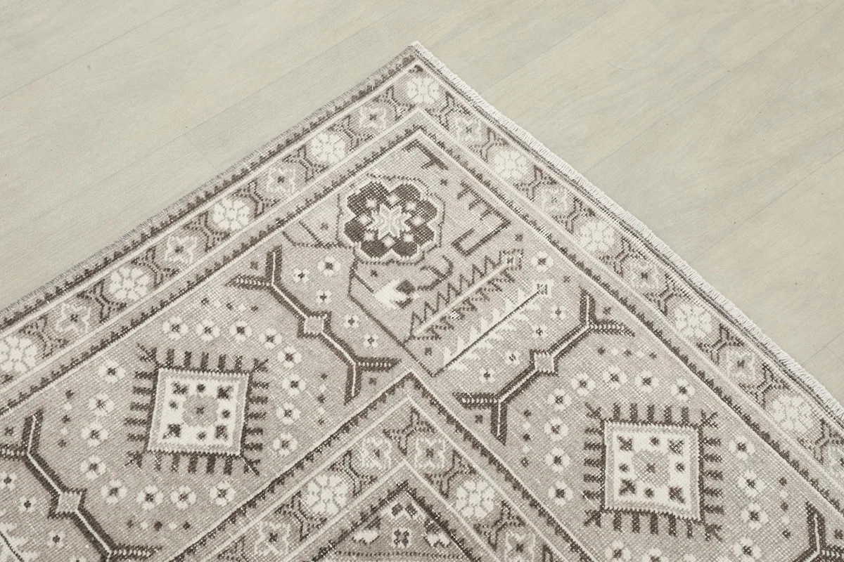 Corner detail showing the patterned border design and the overall color harmony of the rug