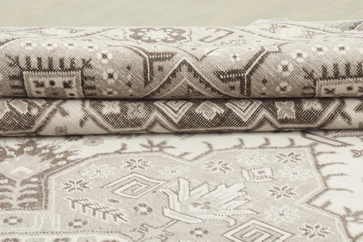 Stacked view of the folded rug, highlighting the low pile and texture of the wool