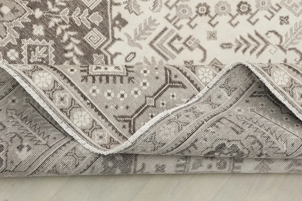 Rolled edge of the rug, showing the reverse side and the consistent pattern