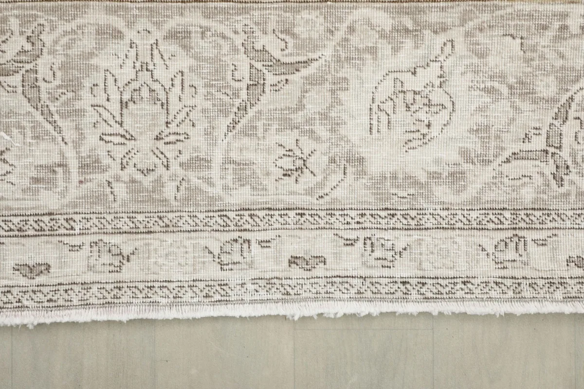 Close-up of the rug's border and short fringe, showcasing the weave and color variations