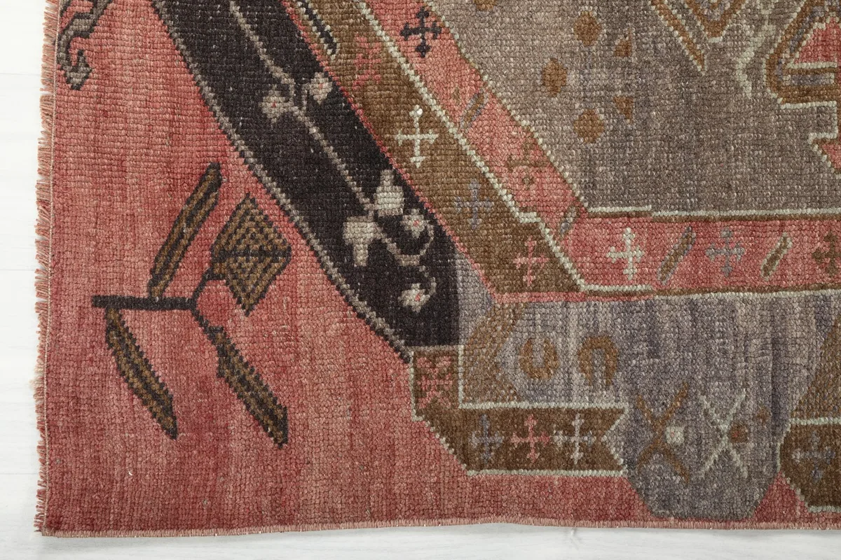 Close-up of the rug's border and end design, highlighting the black and brown accents.