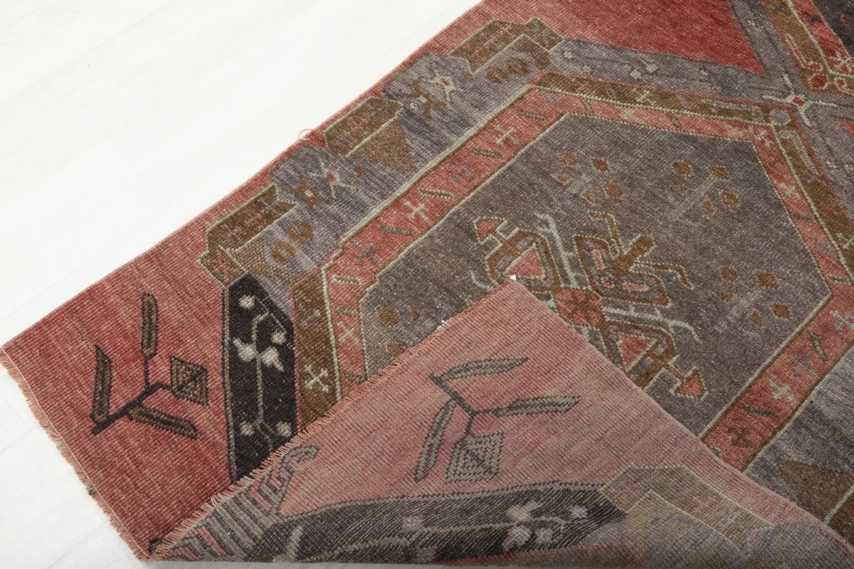 View of the rug folded to show both the front pattern and the reverse side with its cotton foundation.