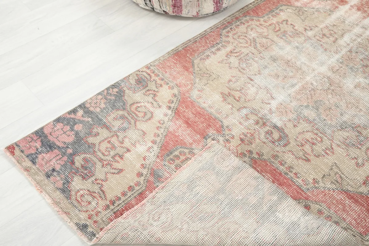 Corner of the rug folded back, revealing the cotton foundation