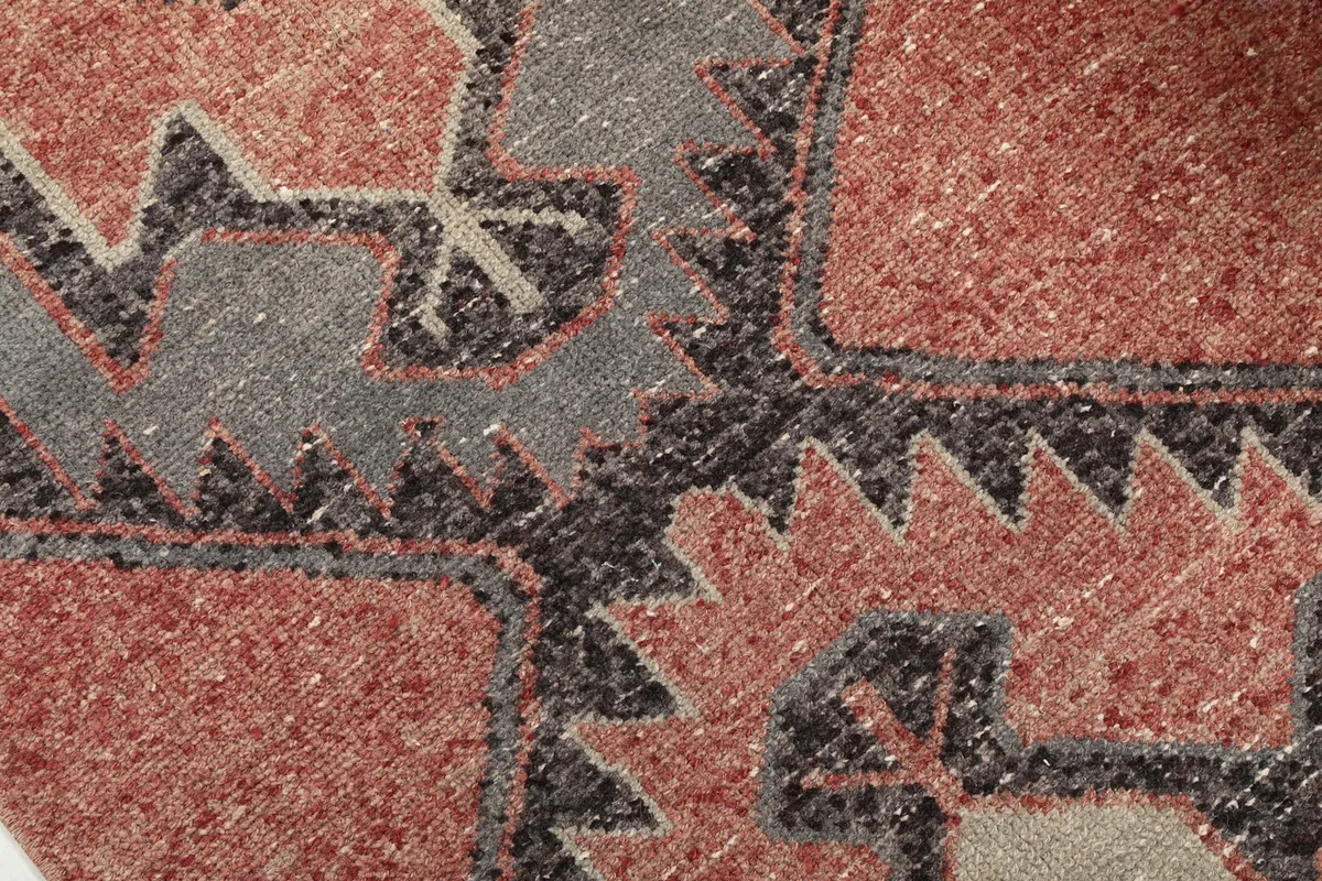 Detailed close-up of the hand-knotted wool pile, showcasing the geometric tribal pattern and color variations.