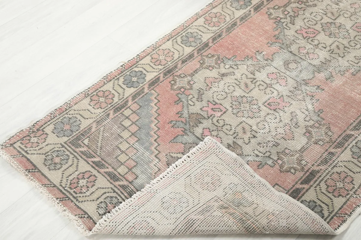 View of the rug folded back to show the cotton foundation and reverse side of the knots