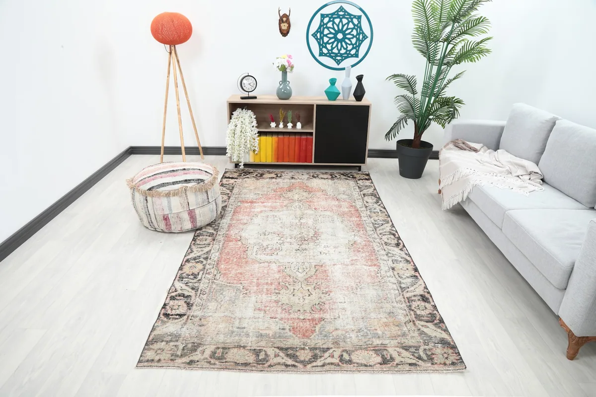 Vintage Anatolian rug displayed in a modern living room setting from a wide angle.