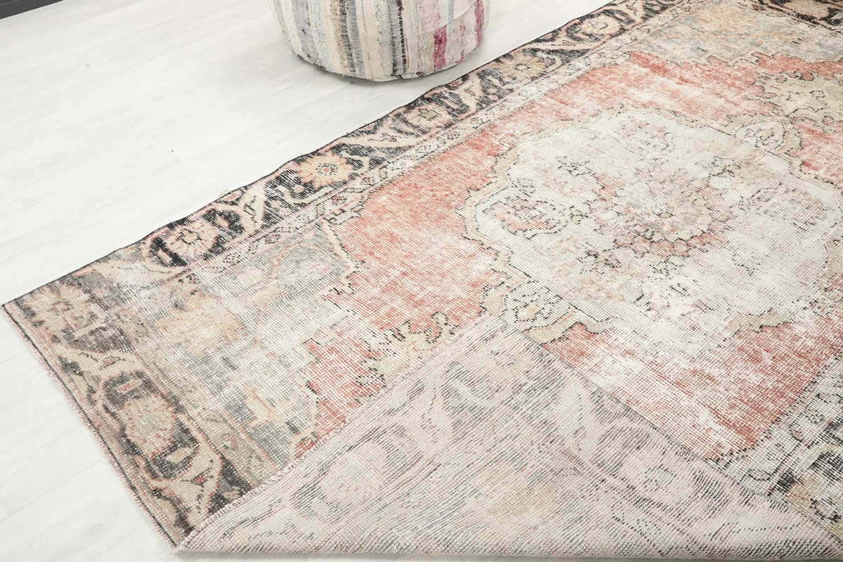 Corner of the rug folded back, showing the cotton foundation and reverse side.