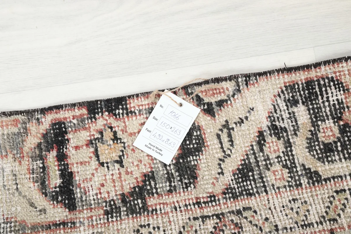 Close-up of the rug's tag attached to the border, showing product information.