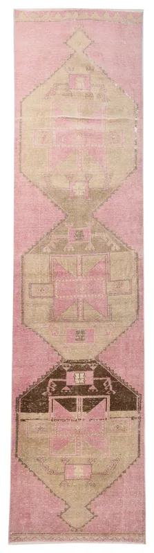 Full overhead view of the pink and brown geometric vintage Anatolian runner rug on a white background.