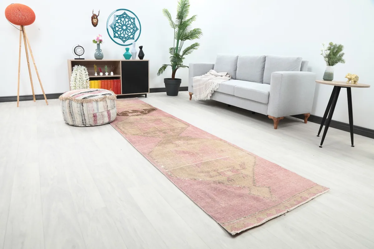 Angled view of the pink and brown runner rug extending down a hallway, showing its length in a home setting.